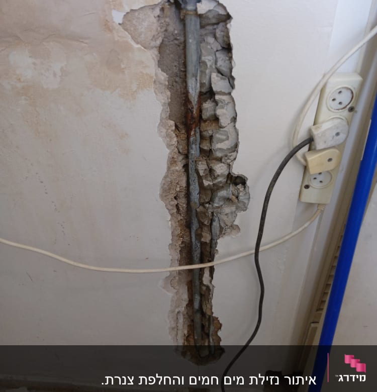 צינור חלוד בקיר חשוף עם חוטי חשמל